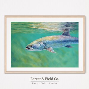 Puede incluir: Una impresión artística enmarcada que presenta una ilustración detallada de un pez sábalo nadando bajo el agua. El pez tiene un cuerpo plateado con reflejos azules y amarillos, sobre un fondo turquesa y verde. La impresión está enmarcada en un marco de madera clara. El texto "FOREST & FIELD CO." está en la parte inferior.