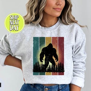 Retro Bigfoot Silhouette With Forest And Striped Sweatshirt, Vintage Sasquatch Forest Shirt, Cryptid Lover Gifts, Funny Hiking Shirt - TC319