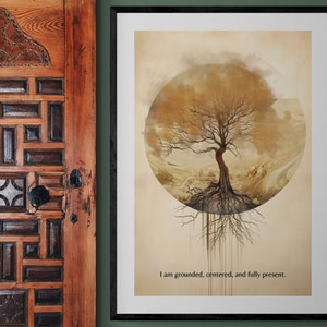 May include: A framed print with a watercolor painting of a tree with roots extending down from the trunk. The tree is surrounded by a circle of clouds and the background is a light brown color. The text "I am grounded, centered, and fully present." is printed below the tree.