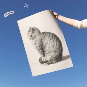 a person holding up a drawing of a cat