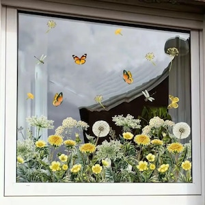 May include: A window decal featuring a vibrant floral and butterfly design. The decal includes yellow dandelions, white wildflowers, and orange butterflies. The design is set against a window frame, creating a decorative and nature-inspired aesthetic.