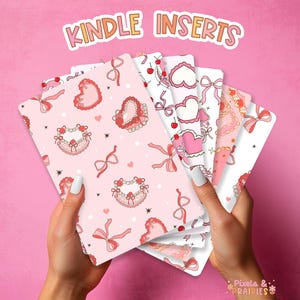 May include: A set of eight pink and white Kindle inserts with various patterns featuring hearts, bows, and stars. The inserts are designed with a cute and girly aesthetic. The text "Kindle Inserts" is visible at the top of the image.