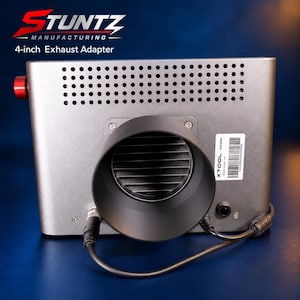 May include: A silver Stuntz Manufacturing 4-inch Exhaust Adapter with a perforated top panel, a large black circular exhaust port, a red knob on the left side, and two black power cables connected to the base of the unit with an Xtool label.