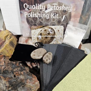 May include: A Petoskey stone polishing kit with a brochure that reads "Quality Petoskey Polishing Kit". The kit includes Petoskey stones, sandpaper, polishing powder, and a black velvet bag. The kit is designed for polishing Petoskey stones.