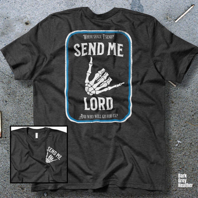 Puede incluir: Camiseta gris oscuro jaspeado con un dise&ntilde;o rectangular. El dise&ntilde;o presenta las palabras "SEND ME LORD" en blanco, con un gesto de mano de esqueleto. Tambi&eacute;n se incluye el texto "WHOM SHALL I SEND?" y "AND WHO WILL GO FOR US?"