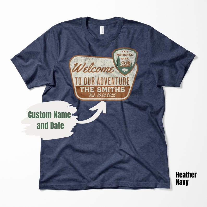 Puede incluir: Una camiseta azul marino con un letrero de estilo vintage que dice "Bienvenido a nuestra aventura The Smiths Est. 10.01.2025". El letrero tiene un logotipo de parque nacional con una monta&ntilde;a y un bisonte.