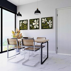 May include: A dining room set featuring a light wood table, four chairs with woven backs, and three framed floral artworks. The room includes a large window and two black pendant lights.