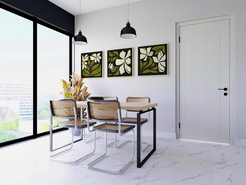 May include: A dining room set featuring a light wood table, four chairs with woven backs, and three framed floral artworks. The room includes a large window and two black pendant lights.