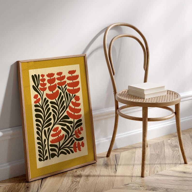 K&ouml;nnte beinhalten: Ein gerahmter Druck mit gelbem Hintergrund und einem stilisierten Blumendesign. Die Blumen sind rot und die Bl&auml;tter sind gr&uuml;n.