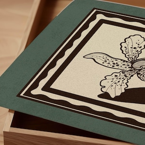 Op de afbeelding: Een rechthoekige, turquoise dienblad met een bloemenontwerp. De dienblad heeft een beige achtergrond met een gedetailleerde bruine orchidee-illustratie. De orchidee wordt omlijst door een bruine rand met een geschulpte rand.