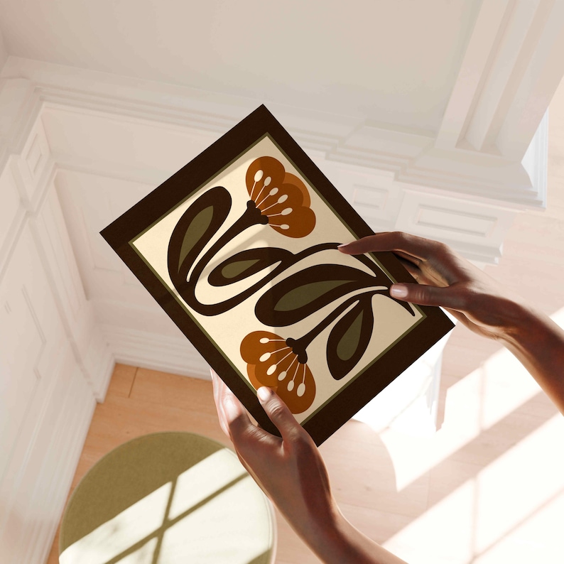 Puede incluir: Una impresi&oacute;n art&iacute;stica enmarcada con un dise&ntilde;o floral estilizado en tonos marr&oacute;n, verde oliva y crema. La obra de arte es sostenida por manos, mostrando los colores y la composici&oacute;n de la impresi&oacute;n. La impresi&oacute;n tiene un marco marr&oacute;n oscuro.
