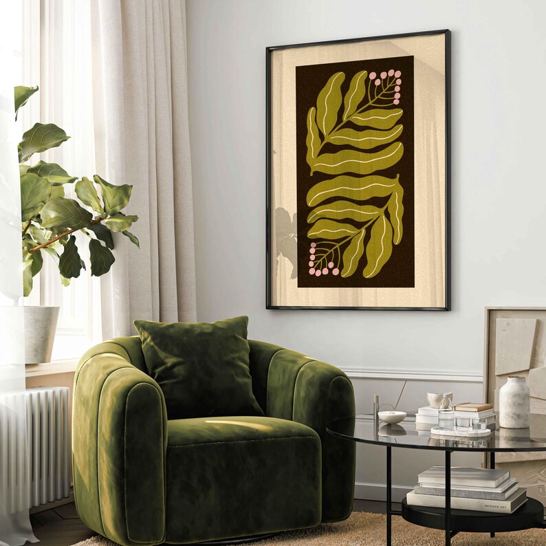 Pu&ograve; includere: Una stampa botanica incorniciata con foglie verde oliva e bacche rosa su sfondo marrone scuro. L'opera d'arte, in una cornice nera, &egrave; appesa sopra una poltrona di velluto verde, creando un design d'interni moderno e accogliente.