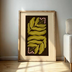 Pu&ograve; includere: Una stampa botanica incorniciata con un design a foglie stilizzate in verde oliva e bianco su sfondo marrone scuro. La stampa include piccoli grappoli di bacche rosa. L'opera d'arte &egrave; esposta in una cornice di legno chiaro.