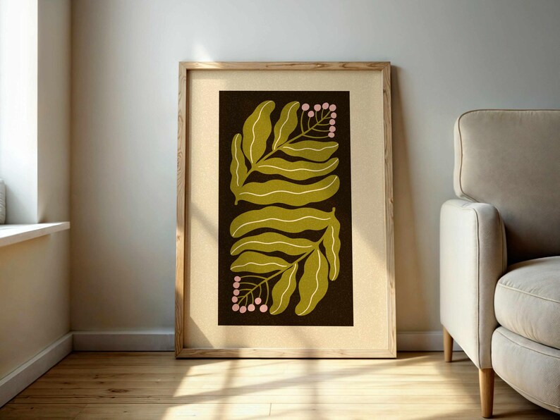 Pu&ograve; includere: Una stampa botanica incorniciata con un design a foglie stilizzate in verde oliva e bianco su sfondo marrone scuro. La stampa include piccoli grappoli di bacche rosa. L'opera d'arte &egrave; esposta in una cornice di legno chiaro.