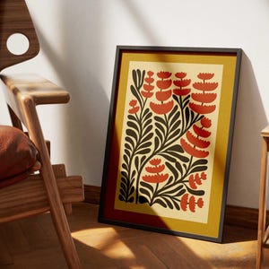 K&ouml;nnte beinhalten: Ein gerahmter Druck mit einem stilisierten Blumendesign. Der Druck zeigt rote und schwarze Blumen auf gelbem Hintergrund.