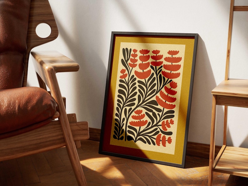 K&ouml;nnte beinhalten: Ein gerahmter Druck mit einem stilisierten Blumendesign. Der Druck zeigt rote und schwarze Blumen auf gelbem Hintergrund.