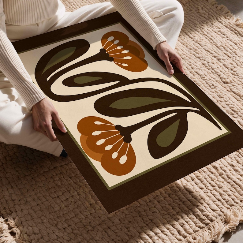 Puede incluir: Una impresi&oacute;n art&iacute;stica enmarcada con un dise&ntilde;o floral retro. La obra de arte presenta flores estilizadas en tonos marr&oacute;n, naranja y verde sobre un fondo crema. El marco es de color marr&oacute;n oscuro, a&ntilde;adiendo una est&eacute;tica vintage.