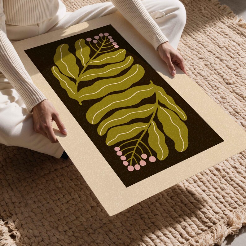Pu&ograve; includere: Una stampa artistica rettangolare con un design botanico. L'opera presenta due grandi foglie verdi stilizzate con venature bianche su uno sfondo marrone scuro. Sono presenti anche piccole bacche rosa. La stampa ha un bordo color crema.