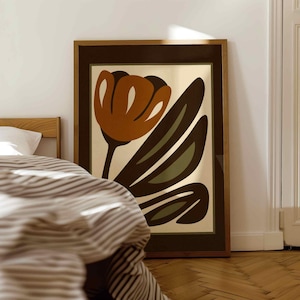 K&ouml;nnte beinhalten: Ein gerahmter Kunstdruck mit einer stilisierten Blume in Braun-, Orange- und Gr&uuml;nt&ouml;nen. Das Kunstwerk ist vor einem cremefarbenen Hintergrund platziert und in einem dunkelbraunen Holzrahmen gerahmt. Der Druck wird in einem Schlafzimmer gezeigt.