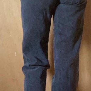 Puede incluir: Vaqueros negros de tiro alto con canes&uacute; trasero en forma de V, trabillas para cintur&oacute;n y bajo deshilachado en los tobillos. Los pantalones presentan un corte recto y una construcci&oacute;n cl&aacute;sica de cinco bolsillos en tejido denim negro lavado.