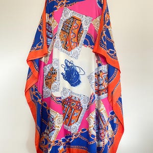 May include: A long, flowing, pink, orange, and blue patterned kaftan with a chain link design. The kaftan has a round neckline and is made of a silky fabric.