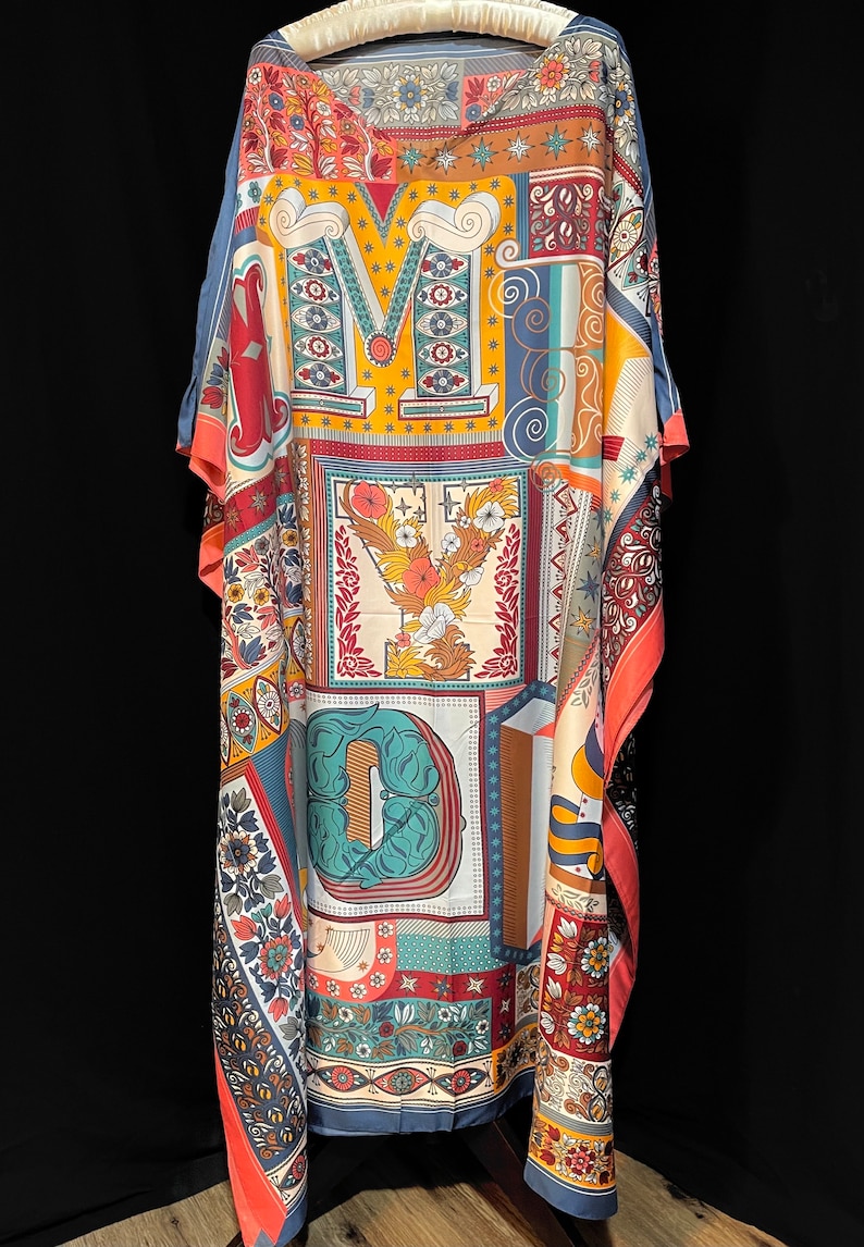 May include: A long, flowing, blue, red, orange, and yellow patterned kaftan with a large, colorful, graphic print of the letters "MYD".