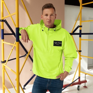 Könnte beinhalten: Eine neon-grüne Kapuzenjacke mit einem schwarzen Patch, auf dem "Trifaux Fashion Milan" auf der linken Brust steht.