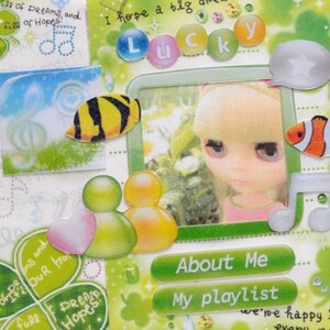 May include: A scrapbook page with a green and white theme, featuring a photo of a doll, fish stickers, and the word "Lucky". Decorative elements include musical notes, clovers, and text that reads "About Me" and "My playlist".