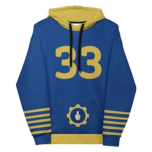 May include: Blue hoodie with a yellow hood and accents. The number "33" is displayed in yellow on the front. A gear logo with a thumbs-up is on the front pocket. The sleeves have yellow stripes.
