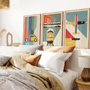 May include: Three framed prints with a Bauhaus theme. The prints feature a red, yellow, and blue airplane, a yellow train, and a yellow car with a red roof. The prints are hung on a white wall above a bed with brown and white bedding.