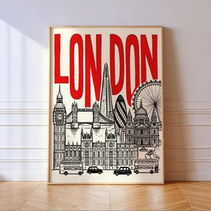 Peut inclure: Impression artistique encadr&eacute;e repr&eacute;sentant des monuments de Londres en noir et blanc, dont Big Ben, le Tower Bridge et le London Eye. Le mot "LONDON" est &eacute;crit en rouge en haut.
