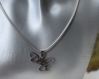 Op de afbeelding: Een zilveren ketting met een zilveren hanger waarop in cursief schrift "Do It" staat.
