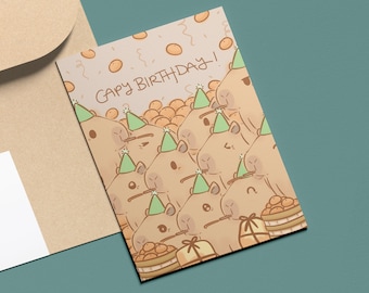 May include: A birthday card with a cartoon illustration of a group of capybaras wearing party hats and surrounded by orange confetti. The card reads "Capy Birthday!"