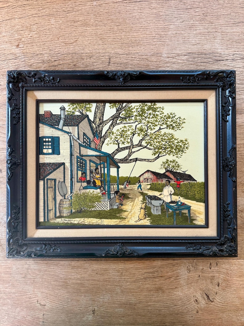 Peut inclure: Une peinture encadr&eacute;e repr&eacute;sentant une sc&egrave;ne de campagne avec une maison blanche, un grand arbre et des gens rassembl&eacute;s autour d'une table. La maison a un porche avec une balan&ccedil;oire et un drapeau accroch&eacute; au toit. Les gens sont habill&eacute;s en v&ecirc;tements d&eacute;contract&eacute;s et profitent du plein air. La peinture est r&eacute;alis&eacute;e dans un style r&eacute;aliste avec des couleurs vives.