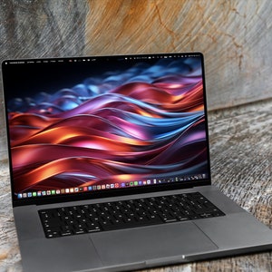 May include: A silver laptop computer with a black keyboard and a dark grey trackpad. The screen is displaying a colourful abstract wallpaper with swirling lines of red, orange, blue, and purple.