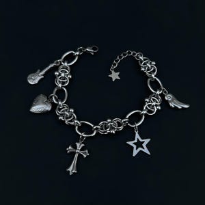 May include: A silver charm bracelet with a variety of charms, including a heart, a star, a guitar, a cross, and a wing. The bracelet is made of a thick, chunky chain.