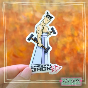 May include: A sticker featuring a cartoon illustration of a muscular samurai holding two hammers. The text "Samurai Jacked" is written in red and black letters below the character.