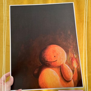 May include: A painting of a cartoon character with orange skin and a flame on its tail. The character is smiling and has a dark background. The painting is titled "Indoor Lighting" and signed "Lil' Guy Studio".