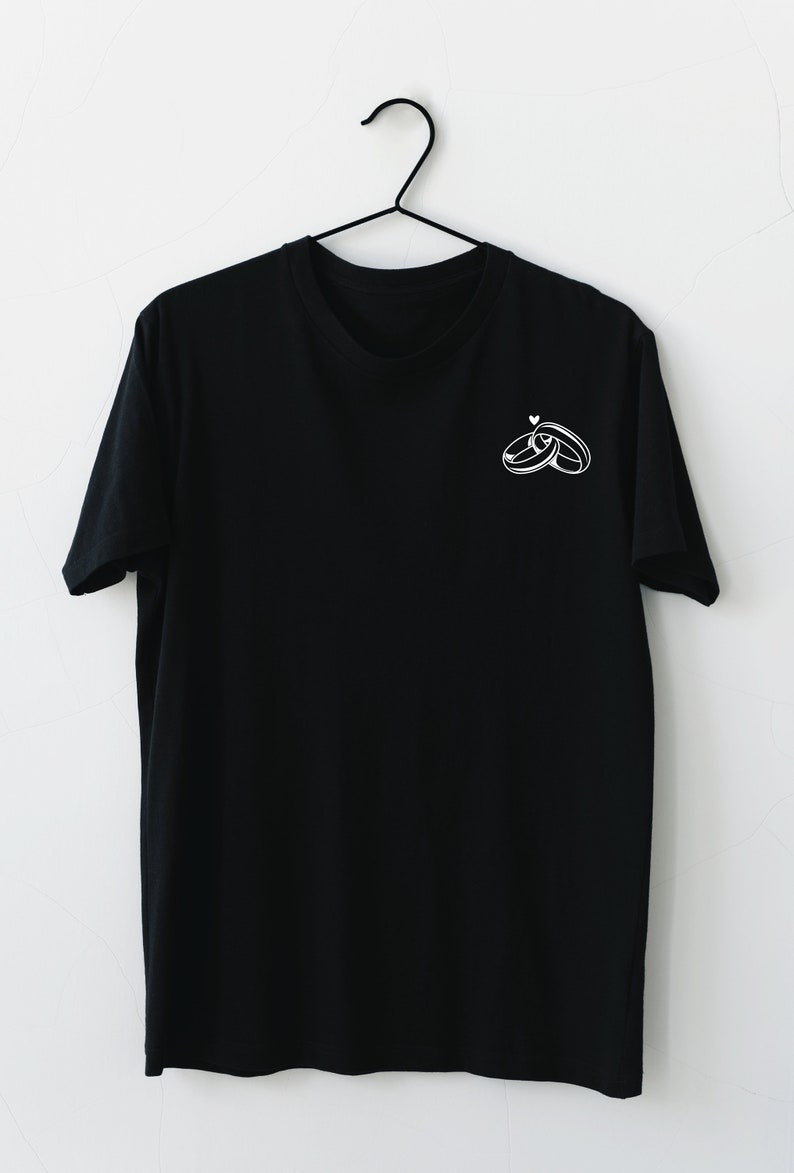 May include: A black t-shirt with a white graphic of two interlocking rings with a small heart above them.