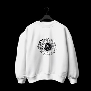 Puede incluir: Sudadera blanca con un gr&aacute;fico en blanco y negro de un girasol con mariposas volando.