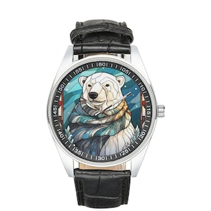 May include: A silver wristwatch with a black leather strap features a colourful illustration of a polar bear wearing a scarf. The watch face has black numbers and markings.