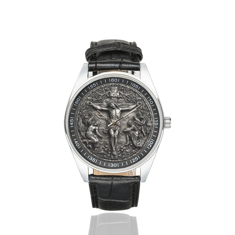 May include: A silver wristwatch with a black leather band. The watch face features a detailed, engraved image of Jesus Christ on the cross.