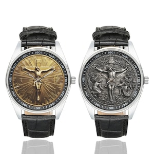 May include: Two silver wristwatches with black leather bands. The watch faces feature a gold and silver image of Jesus Christ on the cross. The gold watch face has a sunburst design. The silver watch face has a more detailed image with a background of trees and people.