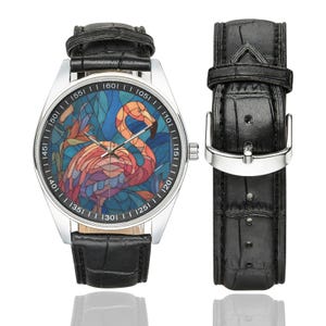 May include: A silver wristwatch with a black leather band and a separate strap. The watch face features a colorful stained-glass design of a flamingo. The watch has a silver bezel with black markings.