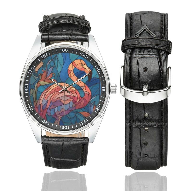May include: A silver wristwatch with a black leather band and a separate strap. The watch face features a colorful stained-glass design of a flamingo. The watch has a silver bezel with black markings.
