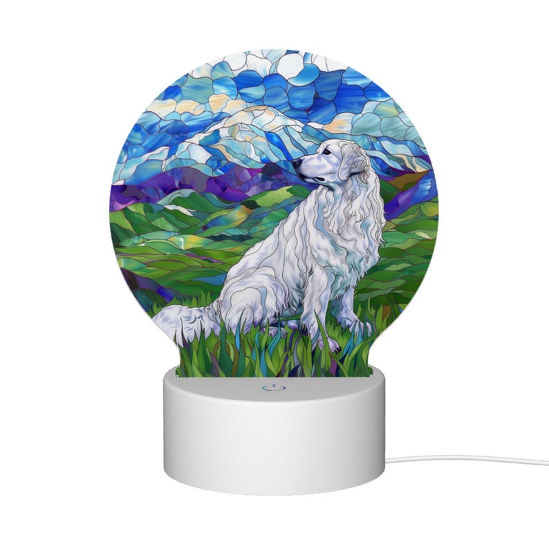 May include: A white 3D printed night light shaped like a circle with a stained glass design of a white dog sitting in a field with mountains and a blue sky in the background.