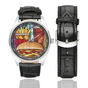 K&ouml;nnte beinhalten: Eine Edelstahl-Armbanduhr mit schwarzem Lederarmband. Das Zifferblatt zeigt eine farbenfrohe Grafik eines Hamburgers, Pommes Frites und eines Getr&auml;nks. Das Armband ist ca. 23 cm lang.