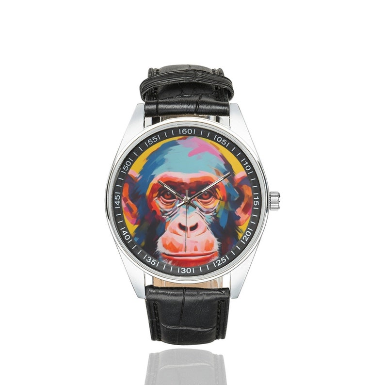 Peut inclure: Une montre-bracelet argent&eacute;e avec un bracelet en cuir noir. Le cadran de la montre pr&eacute;sente une peinture abstraite color&eacute;e d'un visage de singe.