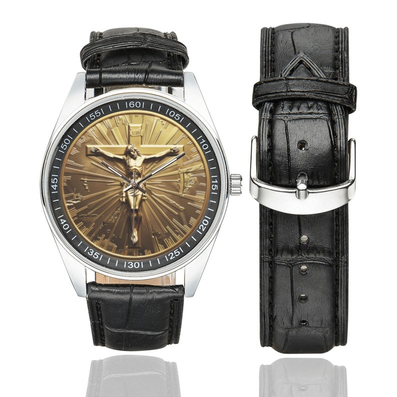 May include: A black leather wristwatch with a silver face and a gold-toned image of Jesus Christ on the cross. The watch face has numbers around the edge and a black leather band.