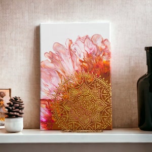 Può includere: Dipinto astratto su tela con colori rosa, arancio e oro. Il dipinto presenta un grande e intricato disegno di mandala in vernice dorata.